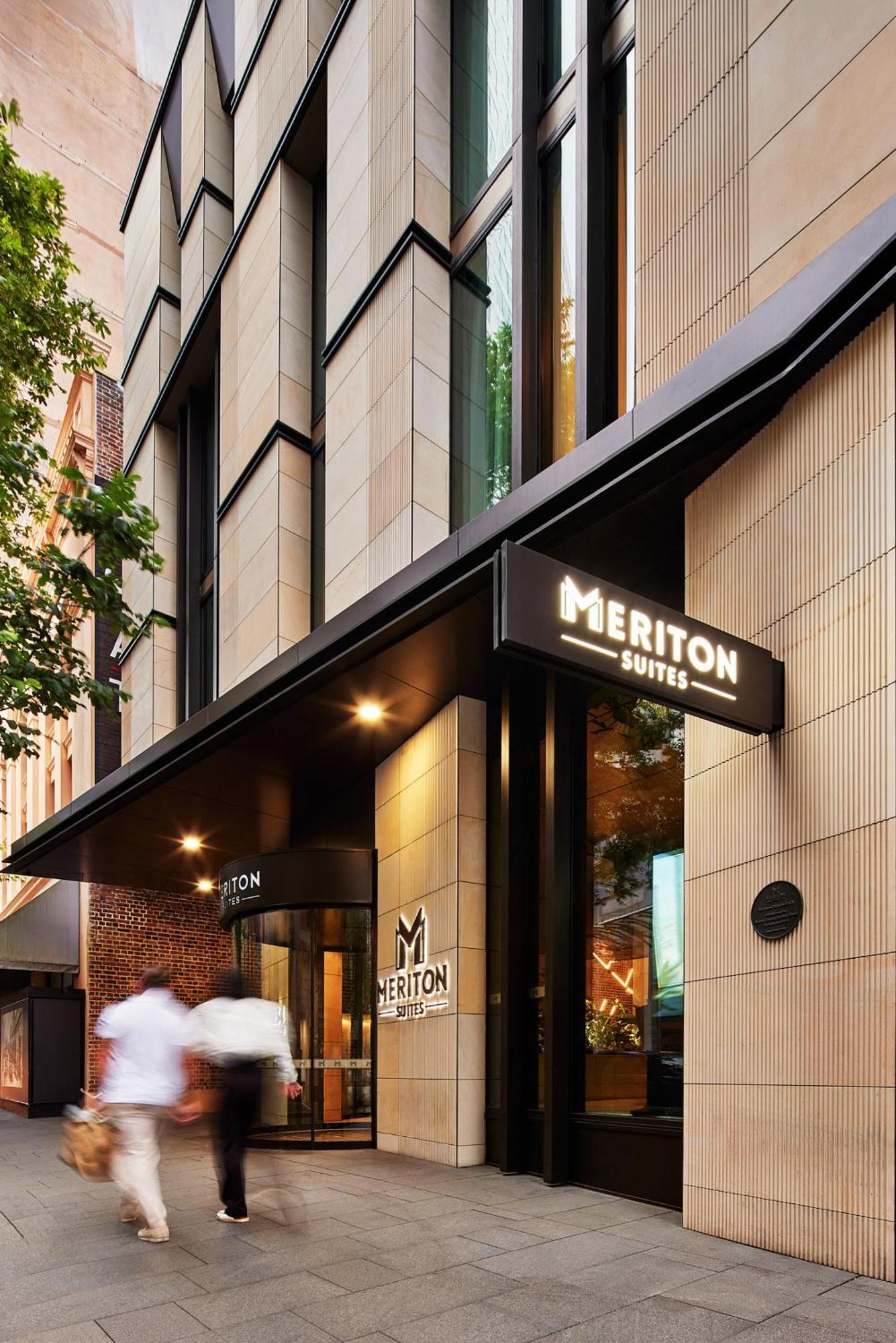 Meriton Suites Sussex Street, Sydney Kültér fotó The photo shows the exterior of a building with the signage for "Meriton Suites." The entrance features a modern design, with sleek architectural elements and large windows. The entrance is highlighted by a prominent awning and illuminated signs, ind